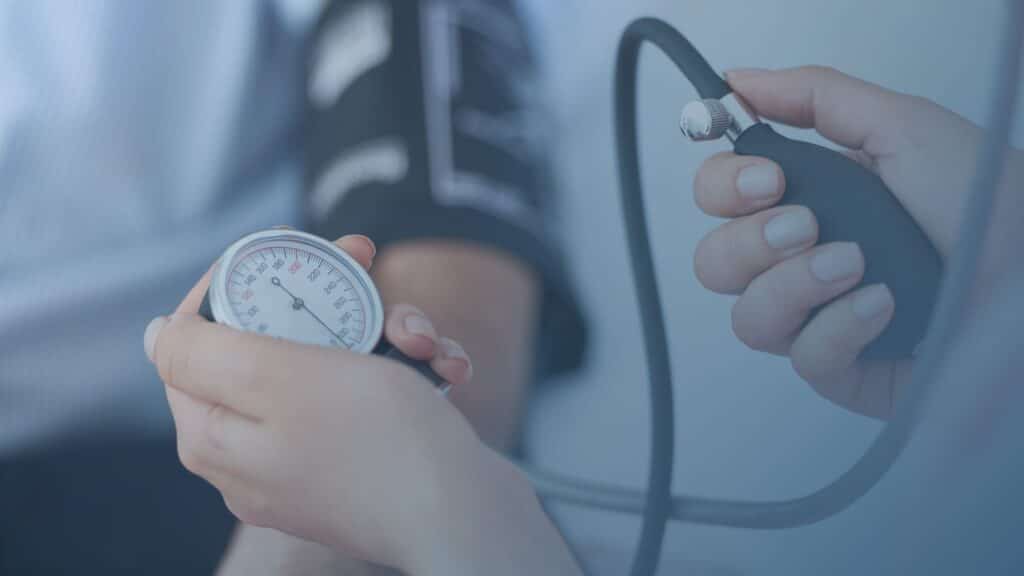 Enfermeira medindo a pressão arterial de um paciente obeso